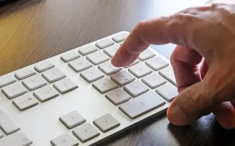 Dłoń naciska klawisz 8 na klawiaturze. W tle widać klawisz Windows.