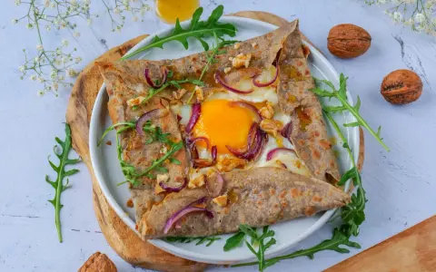 Délicieuse galette de sarrasin garnie d'un œuf, oignons rouges et noix. Parfait pour un repas pour 4 personnes.