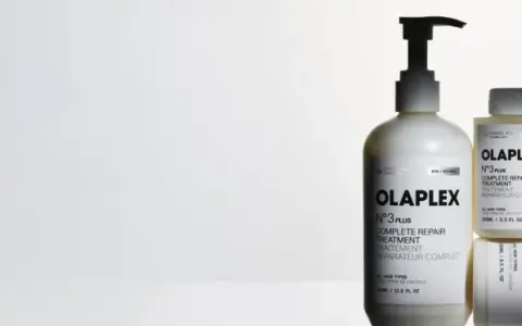 Tres botellas de Olaplex N°3, tratamiento para pelo seco o mojado, en un fondo blanco.