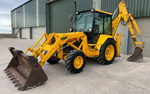 Żółta koparko ładowarka MF 50, gotowa do pracy. Dane techniczne tej maszyny to jej mocne strony.