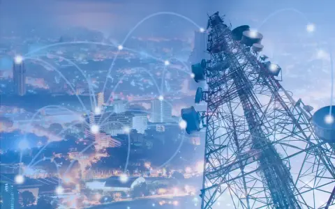 A telecommunications tower overlooks a city, with glowing lines connecting points, symbolizing network planning and optimization.