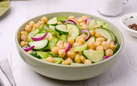 Insalata di ceci estiva con cetrioli freschi, cipolla rossa e sedano croccante, un piatto leggero e saporito.
