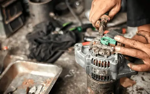 Mechaniker repariert Lichtmaschine, damit das Auto wieder anspringt.