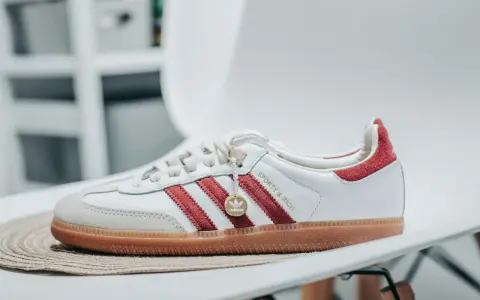 Białe buty adidas Samba z czerwonymi paskami i złotym logo. Sprawdź adidas samba rozmiarówka, by wybrać idealną parę.