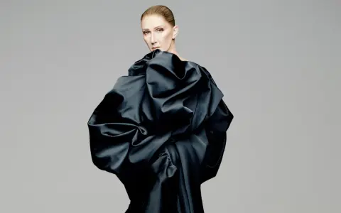 Celine Dion i en dramatisk svart klänning, redo för en oförglömlig konsert.