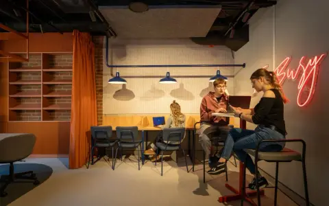 Studenci szukają inspiracji, jak załatwić praktyki studenckie, w nowoczesnym, "busy" wnętrzu.