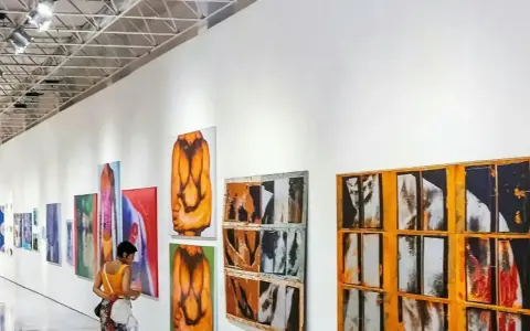 A person views colorful abstract paintings in a modern gallery, a stark contrast to a traditional museum.