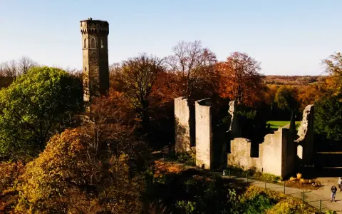 Herbstliche Szene mit dem alten Turm und Ruinen der **Dortmund Syburg** im warmen Licht.