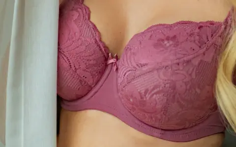 Koronkowe, różowe 36dd biustonosz, ukryty za zasłoną.