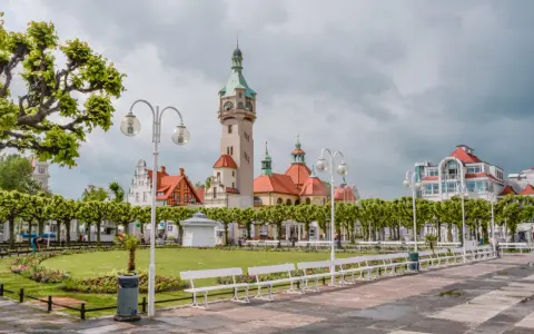 Malowniczy widok na deptak w Sopocie, z charakterystyczną wieżą i budynkami w stylu secesyjnym. Idealne miejsce na spacer między Gdańskiem a Gdynią.