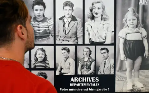Un homme regarde des archives numérisées : portraits d'enfants et d'adultes d'une autre époque.