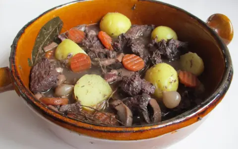 Un plat mijoté, spécialité culinaire Provence, avec du bœuf, des carottes, des pommes de terre et des oignons dans un jus savoureux.