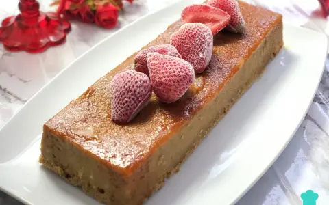 Delicioso pudin de pan casero, cubierto con fresas congeladas y un glaseado dorado.