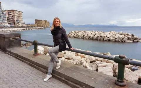 Donna sorridente si gode il panorama di Castel dell'Ovo e del mare, un assaggio di Napoli in 3 giorni.