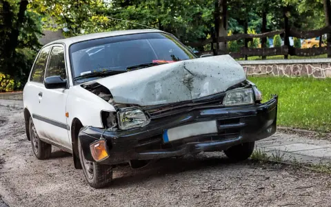 Uszkodzony biały samochód po wypadku. Zastanawiasz się ufg co to? To ubezpieczeniowy fundusz gwarancyjny, który pomaga w takich sytuacjach.