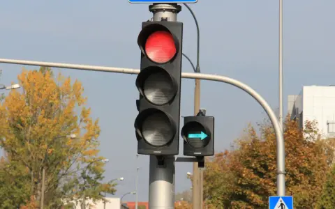 Sygnalizacja świetlna z czerwonym światłem i zielona strzałka wskazująca skręt w prawo.