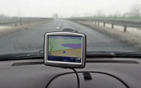 Nawigacja TomTom na desce rozdzielczej samochodu podczas jazdy w mglisty dzień.