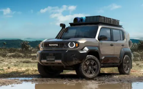 Nowy Toyota Land Cruiser 100 gotowy na przygodę, z bagażnikiem dachowym i terenowymi oponami, w błotnistym krajobrazie.