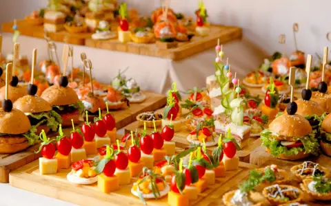 Deliciosos entrantes para boda: mini hamburguesas, canapés de salmón, brochetas de tomate y queso, y tartas saladas.