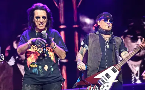 Alice Cooper i Johnny Depp, członkowie Hollywood Vampires, na scenie. Cooper śpiewa, Depp gra na gitarze.