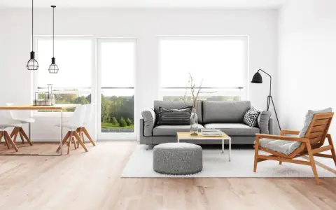 Elegante salón comedor con sofá gris, mesa de centro y sillas blancas. La iluminación es clave para combinar lamparas salon comedor, con colgantes sobre la mesa y una lámpara de pie.