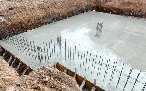 Świeżo wylany beton na budowie, zbrojenie fundamentów gotowe do dalszych prac. Ocieplenie fundamentów będzie kolejnym etapem.