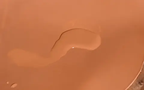 Une tache d'eau sur cuir non traité, créant une légère décoloration.
