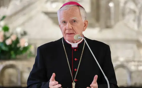 Arcybiskup krakowski w sutannie i piusce przemawia do wiernych.
