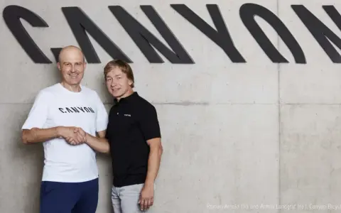 Roman Arnold und Armin Landgraf schütteln sich die Hände vor dem Canyon-Logo.