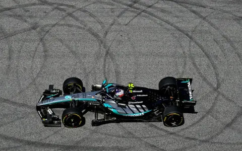 Coche de F1 Mercedes-AMG Petronas en el GP Austria, dejando marcas de neumáticos en el asfalto.