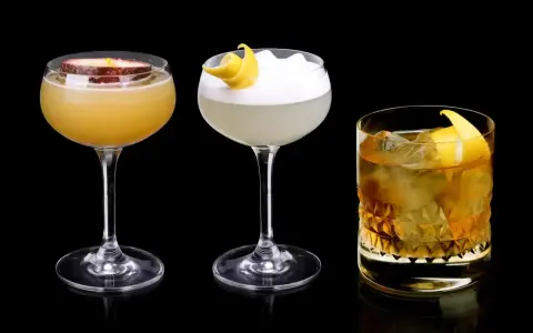 Trzy drinki: jeden z marakują, drugi z pianką i skórką cytryny, trzeci z lodem i skórką cytryny, każdy z nutą Cointreau.