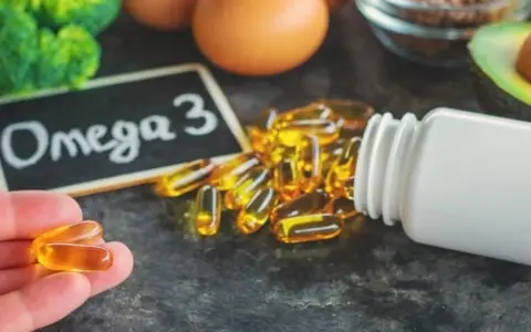 Kapsułki omega 3 na co? Na zdrowie! W tle brokuły, jajka, awokado i siemię lniane.
