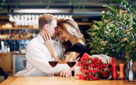 Para świętuje 13 rocznicę ślubu w restauracji, z kieliszkami wina i bukietem czerwonych róż.