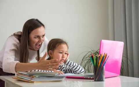 Zła kobieta krzyczy na dziecko przy laptopie.
