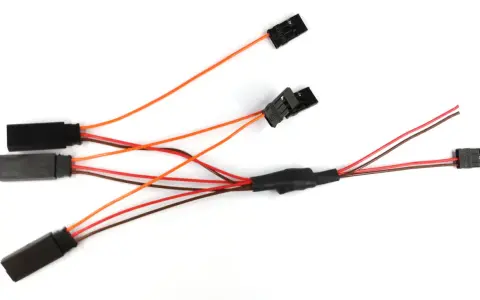 Ein dreiadriges Kabel mit mehreren schwarzen Steckern und bunten Leitungen, das für elektrische Verbindungen verwendet wird.