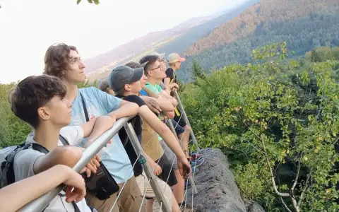 Grupa młodych ludzi na szlaku, podziwiająca widok. Idealne miejsce na pierwsze wyprawy trekkingowe dla początkujących.