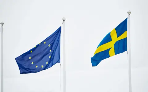 Sveriges flagga och EU-flaggan vajar sida vid sida. En symbol för samarbete inom europeiska unionen.