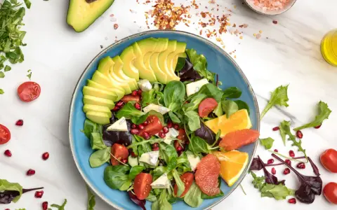 Insalata di avocado fresca con pomodorini, melograno, agrumi e formaggio blu.