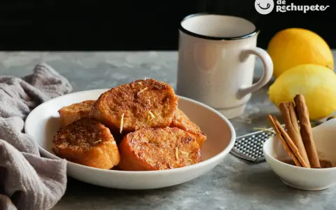 Torrijas de pan doradas y crujientes, espolvoreadas con ralladura de limón. Un clásico de las recetas de torrijas de pan, perfecto para disfrutar.
