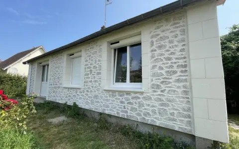 Façade de maison rénovée avec un enduit à la chaux imitant la pierre. Belle utilisation de la chaux pour un aspect authentique.