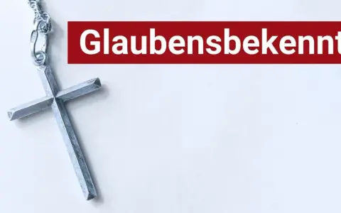 Ein silbernes Kreuz liegt neben dem Schriftzug "Glaubensbekenntnis".