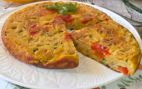 Herzhafte Frittata mit Gemüse, zubereitet in der frittata pfanne oder ofen, garniert mit Basilikum.