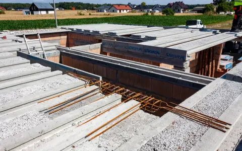 Budowa domu w toku. Widać prefabrykowane stropy Teriva, zbrojenie i pustaki. Dobra strop teriva cena to klucz do szybkiej budowy.