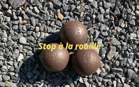 Trois boules de pétanque rouillées sur des graviers. Apprenez comment nettoyer des boules de pétanque pour qu'elles retrouvent leur éclat.