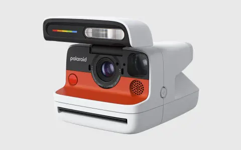 Nowoczesny aparat Polaroid z pomarańczowym akcentem i tęczowym paskiem na lampie błyskowej. To właśnie polaroid, co to za magia!