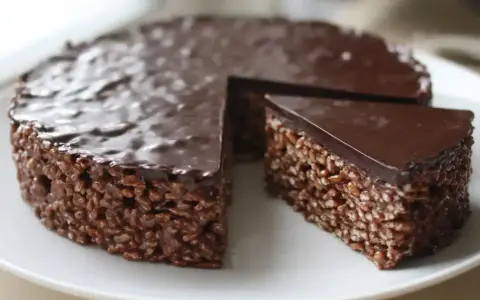 En chokladig rice crisp tårta med en bit borttagen, redo att avnjutas.