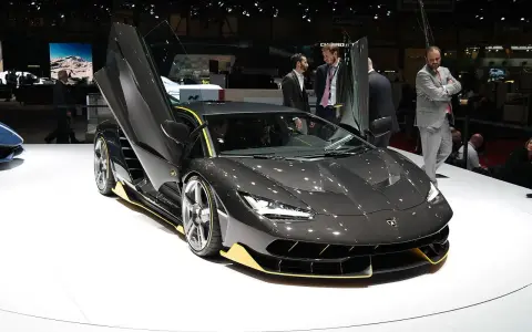 Ciemnoszary Lamborghini z otwartymi drzwiami, żółte akcenty. Zastanawiasz się, ile kosztuje Lamborghini Urus? Ten model to marzenie.