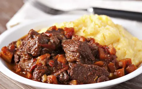 Un plat de daube de sanglier sans marinade, mijoté avec des légumes, servi avec une purée de maïs crémeuse. Un délice !