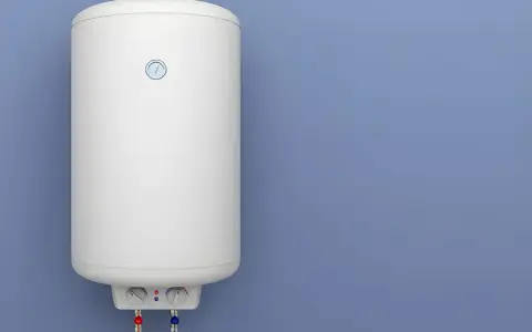 Termo eléctrico no sale agua caliente. El aparato blanco está colgado en la pared azul.