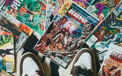 Kolekcja komiksów Marvela, w tym "The Uncanny X-Men" i "Deadpool", leży na dywanie. Idealne dla tych, którzy chcą wiedzieć, jak czytać komiksy Marvela.